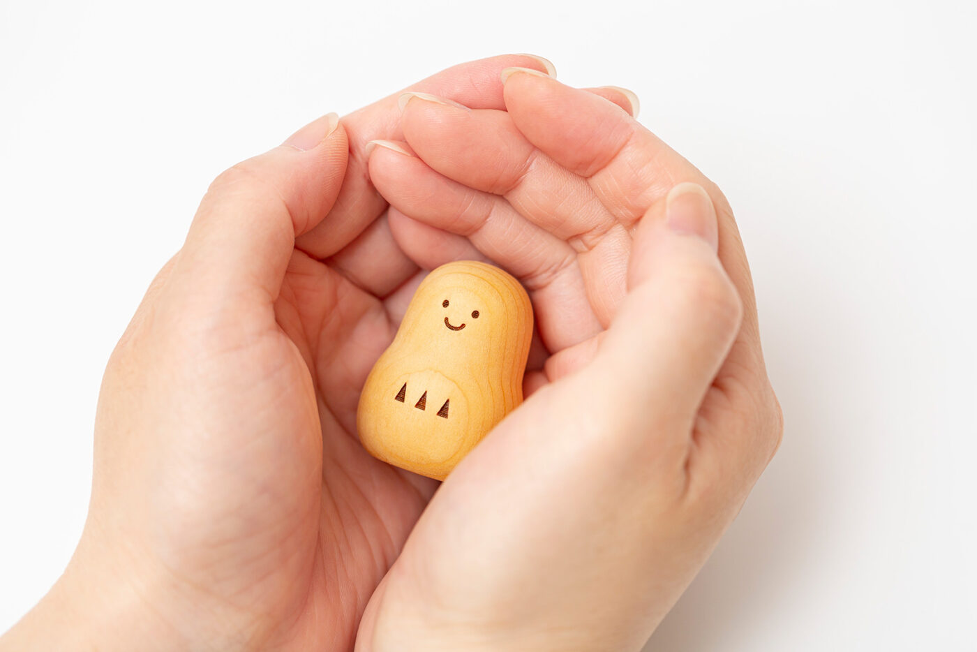 手のひらに収まる、小さな天然木の小だるま。